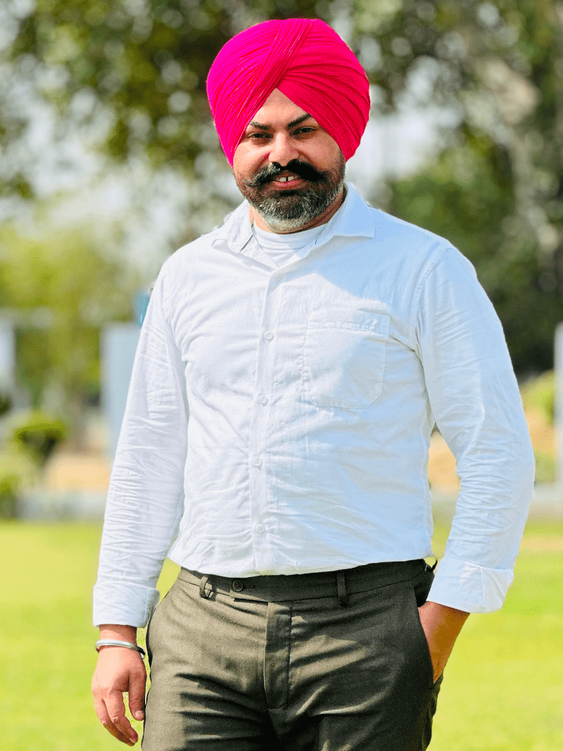 Sewak Singh is posing with a smile in Reddish Color Turban and White Shirt
